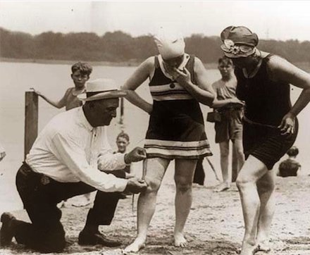 4. A beach official in 1920 measuring bathing suits to make sure they weren't too short.