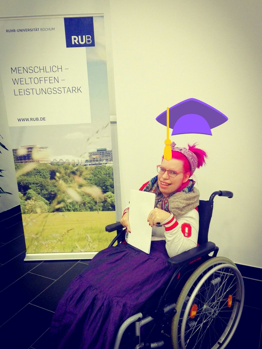 Tanja mit Abschlussurkunde vor einem Schild der Ruhr - Uni Bochum