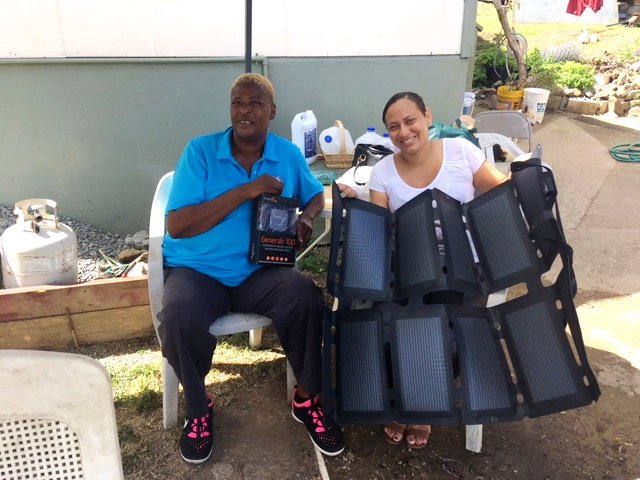 AscentSolar's tweet photo. The damage from hurricanes #Irma and #Maria in the US Virgin Islands last year was devastating. Here, a Disaster Case Manager sits with a citizen who now has access to unlimited power until all can be returned back to normal.  #SolarPowerEverywhere #DisasterRelief @LoveCityStrong https://t.co/h0iL73MxWT