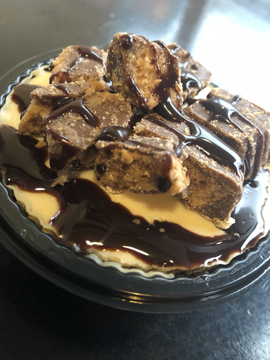 Peanut butter cheesecake topped with Reese’s Peanut butter cup crumble and a chocolate drizzle