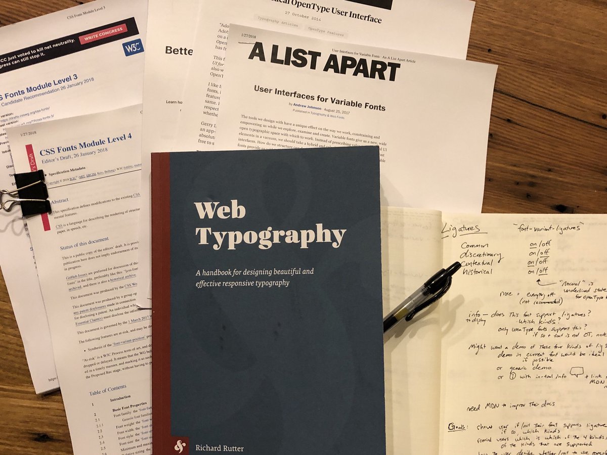 A photo of a pile of papers, CSS specs on Fonts, Richard Rutter’s Web Typography book, and other articles on Variable Font and Feature interface design. Plus my notebook with hand written notes.