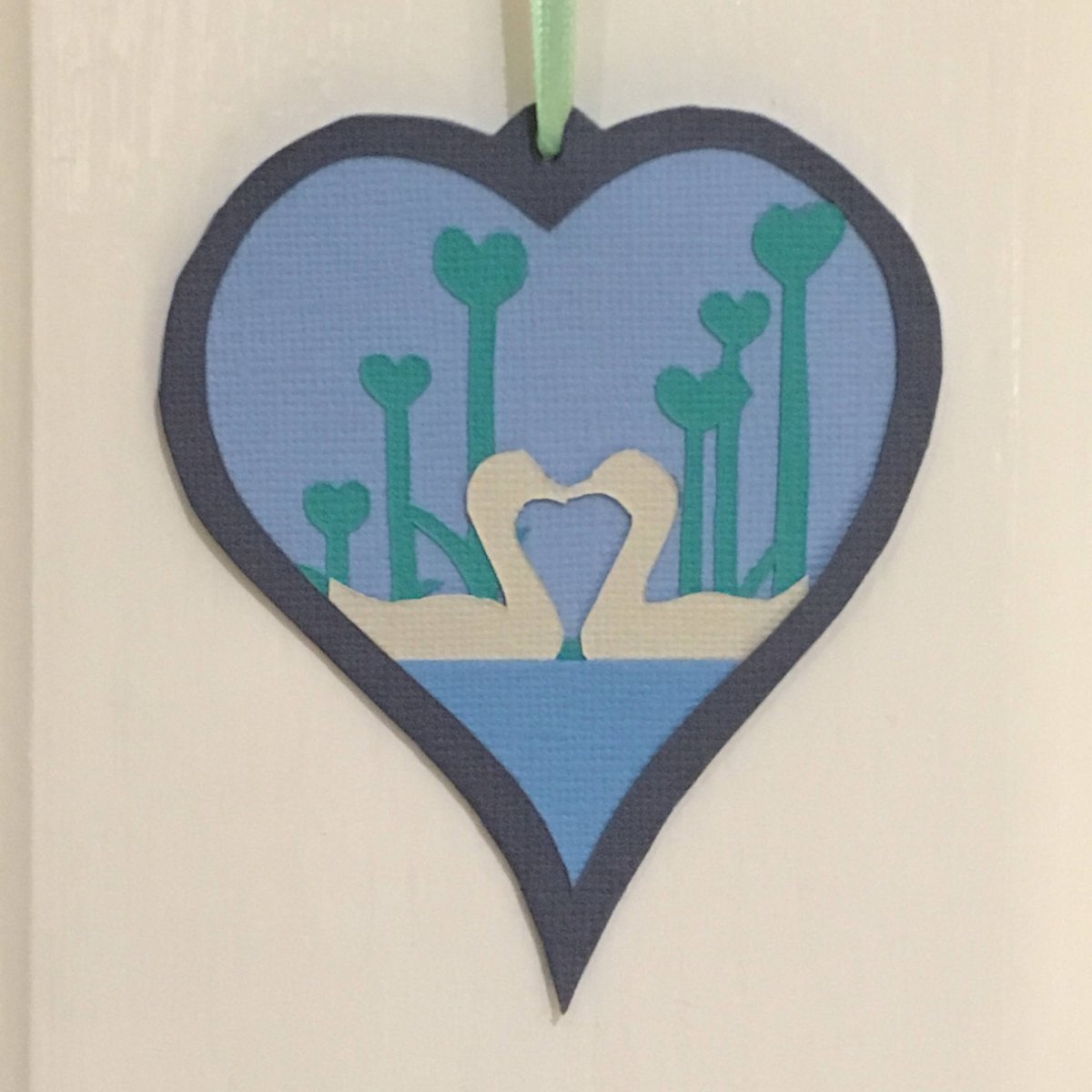 ArtistsDirDevon's tweet photo. Excited to be sharing the latest addition to my #etsy shop: Hanging Heart, Paper cut, With a pair of courting swans on a pond with Heart reeds behind them. https://t.co/qkKdiYrYkr https://t.co/iXyqORA3P9