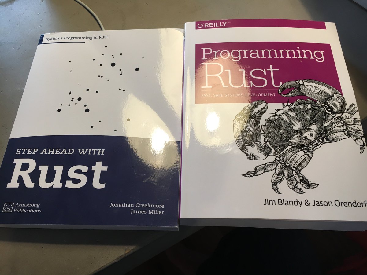 Two books on my kitchen table: "Step ahead with Rust" (Armstrong publications) and "Programming Rust" (O'Reilly)