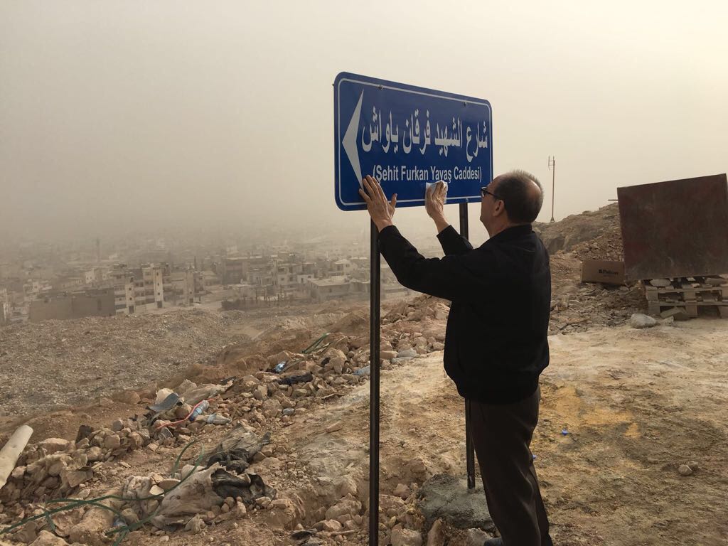 MMazlumcel's tweet image. Fotoğraftaki kişi 2016&apos;da El Bab&apos;ta şehit düşen Astsubay Kıdemli Çavuş Furkan Yavaş&apos;ın babası. El Bab&apos;ta oğlunun adının verildiği caddede yer alan tabelayı siliyor.