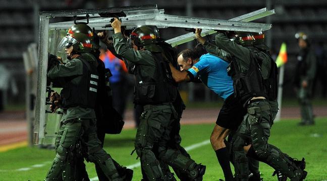 20Minutes's tweet photo. La photo de jour: Un arbitre sort du terrain protégé par des militaires en Copa Libertadores https://t.co/Uiq8d9luJj https://t.co/ZOzYoRc536