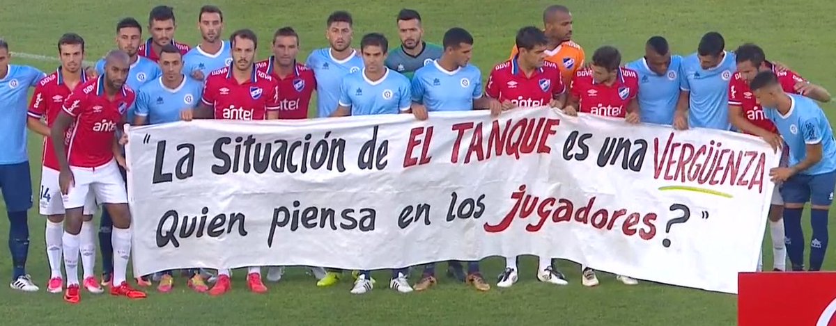 TIRANDO1010's tweet photo. "La situación de #ElTanque es una vergüenza. ¿Quién piensa en los jugadores?", la pancarta que exhibieron los jugadores de #Torque y #Nacional antes del partido en el Centenario https://t.co/QdUOwV2B4n