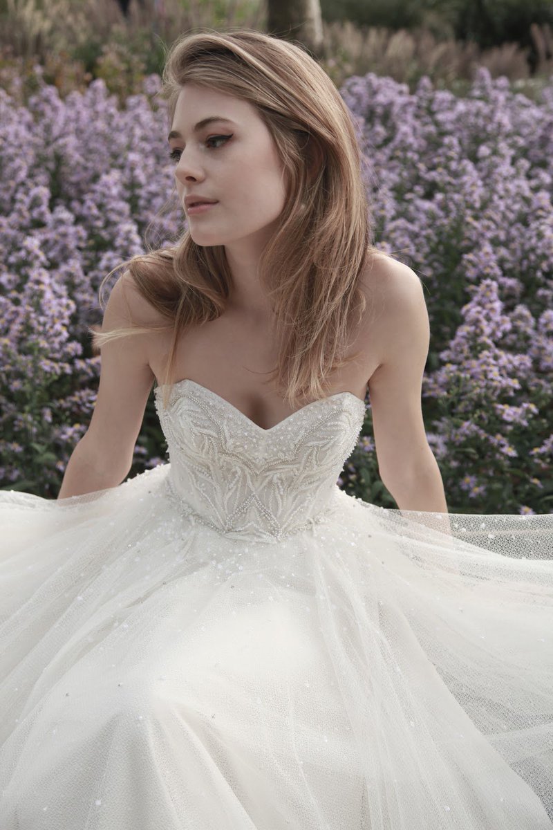 Lush lavender and #WattersCastell. This gown features scattered pearls and shimmering crystals on a lace bodice and dotted net full skirt.