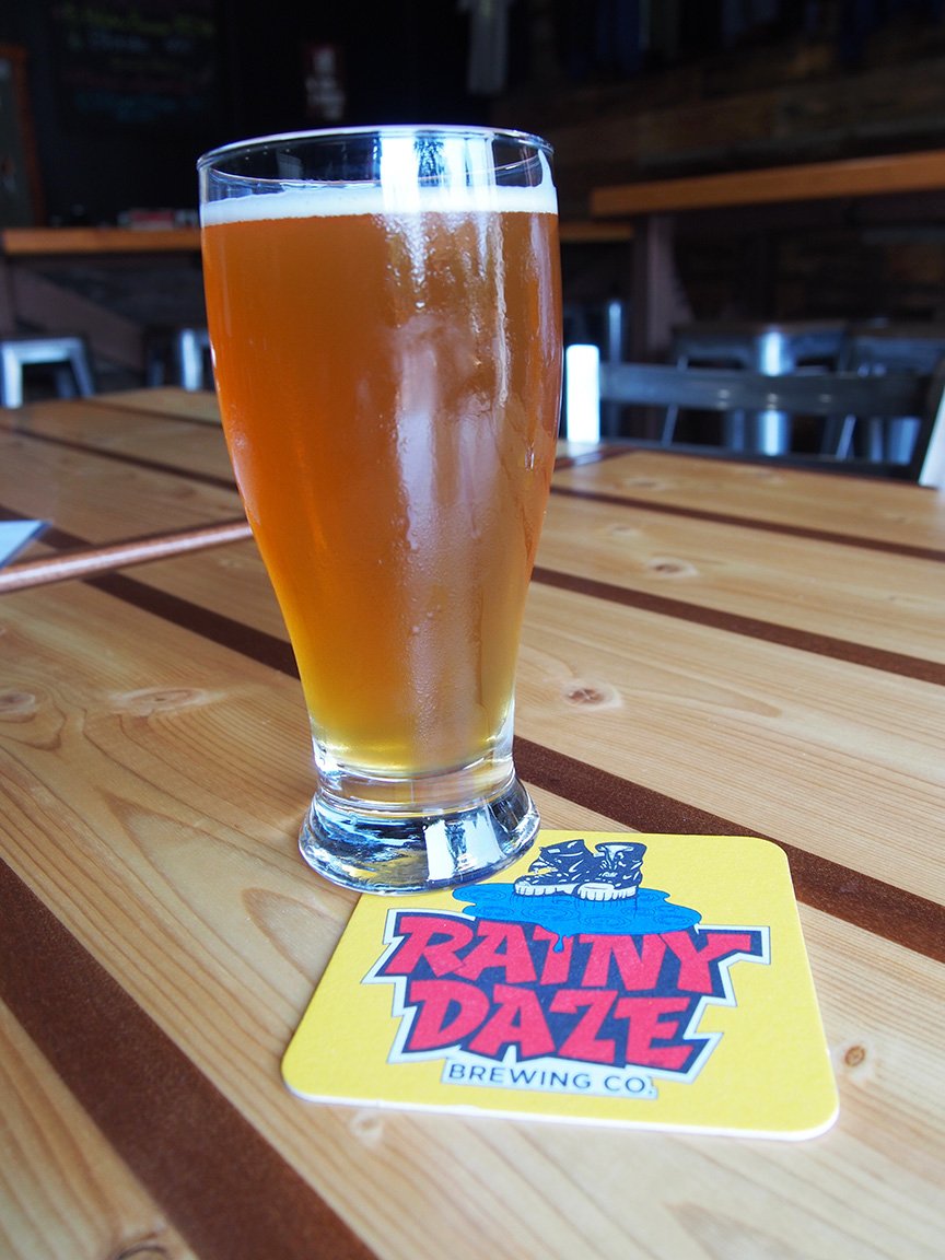 Friendly tasting room &amp; brewery in a bright &amp; airy warehouse. Wood topped bar, lots of barstools, &amp; several tables. Garage door opens to a front patio with picnic tables. 18 beers on tap, including 5 IPA’s. We tried "8 Daze a Week" &amp; "Goat Boater", both excellent! <a href="/RainyDazeBeer/">Rainy Daze Brewing</a>