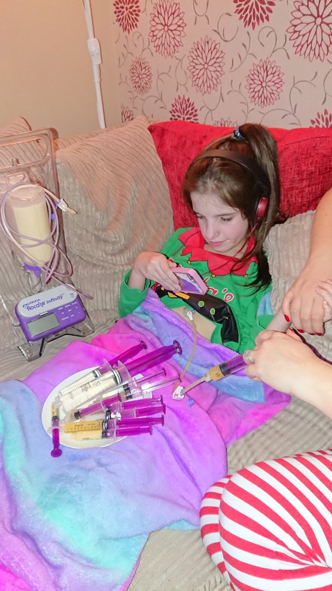 carerclare's tweet photo. Absolutely oblivious that I'm giving her medicines & plugging her into feed after.. It doesn't hurt or annoy her & it certainly doesn't stop her watching the @Avengers on her phone 😊 it keeps her alive & we love it #feedingtubeawarenessweek #i❤️atubie #eat #diffabilities https://t.co/qt56WUaiWV