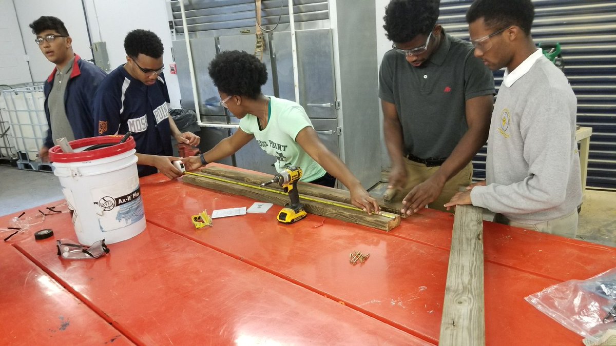 Brianna Collier shows the male students, Micah Williams and Jermarlon Bridges, how it is done when it comes constructing a wood frames. Women in Construction Rock!!!