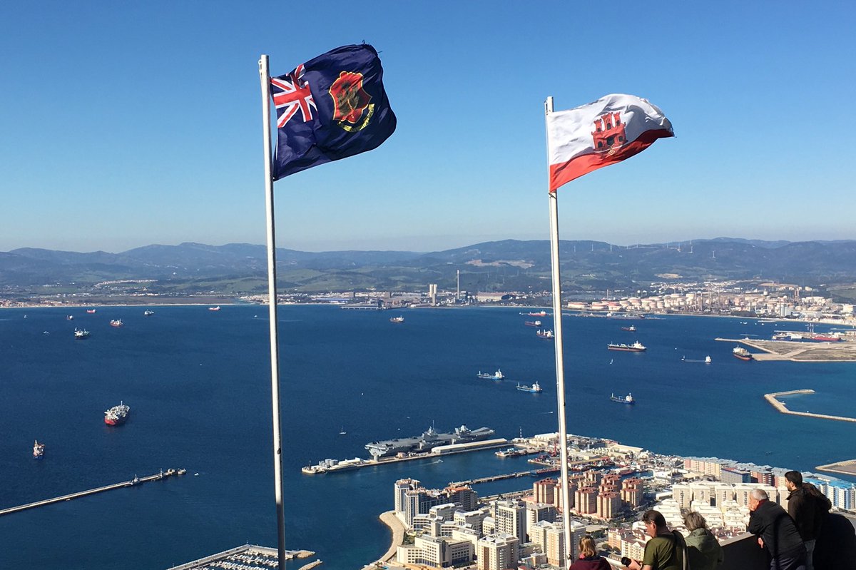 View of harbour from the top of The Rock. The ship is visible in the distance and the Gibraltar flag is in the foreground.