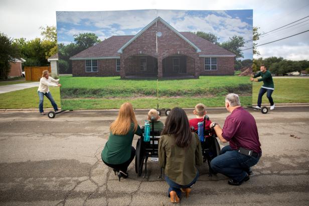 family with children in wheelchairs look at the unveiling of their new home