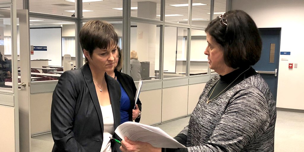 DHS Acting Secretary Teresa Miller looks over some documents while standing inside an EARN center.