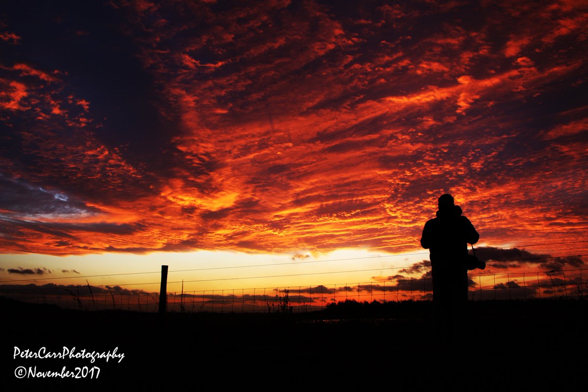Silhouette of nature watcher in front of a stunning volcano red sunset. At RSPB Fairburn Ings (Coal Tips Trail).