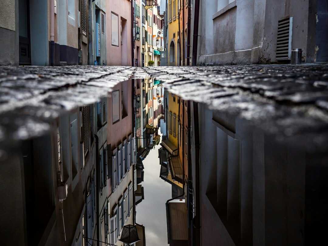 Reflection of a small street in a puddle