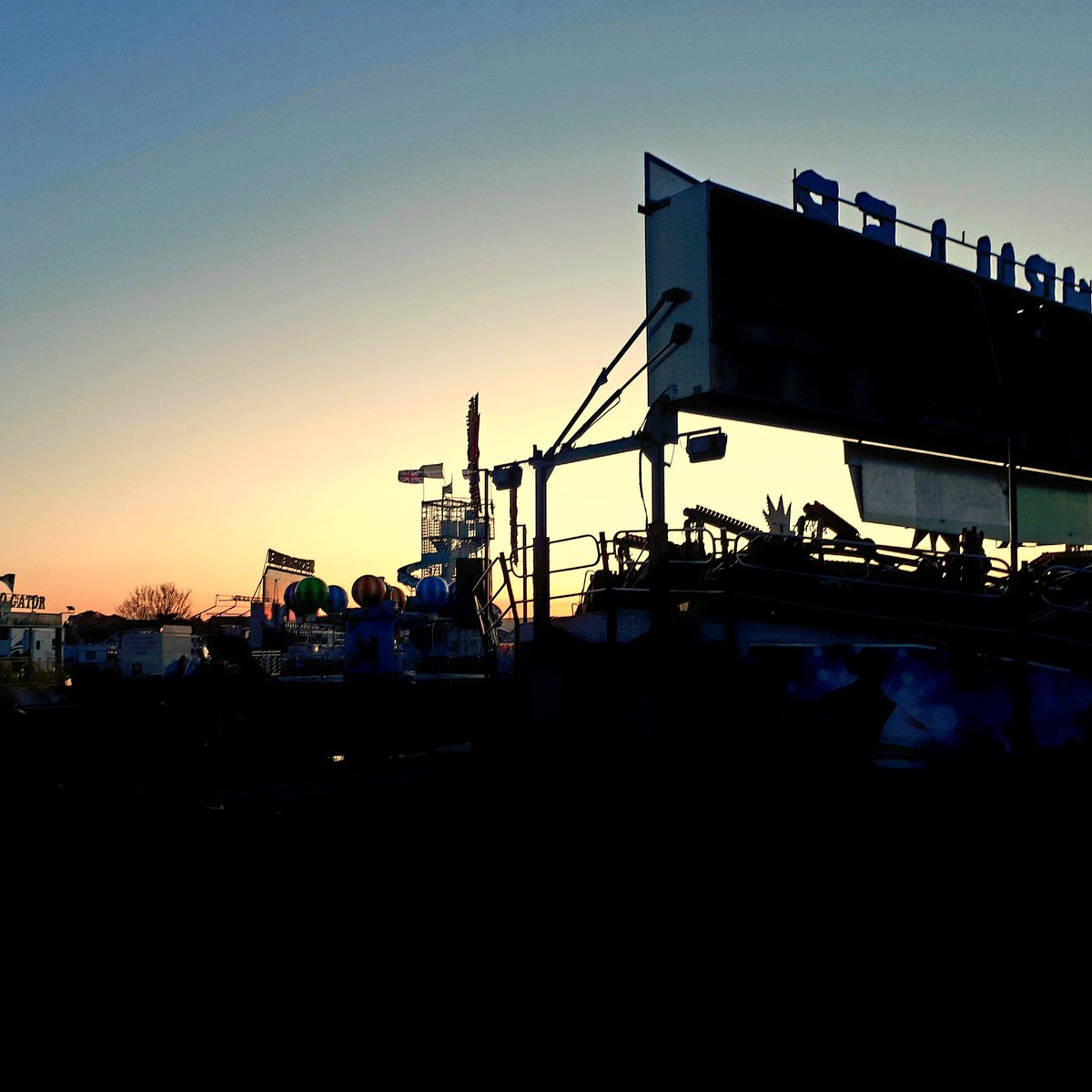 micorsica's tweet photo. sunset in Devon 
the funfair drawing 
lines like a battleship 

#micropoetry https://t.co/162trlqpNh