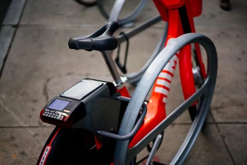 Orange JUMP Bike locked to a bike rack