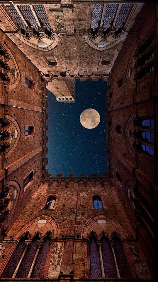 The "Torre Del Mangia" (built ca. 1325-48) and full moon seen from the courtyard of the "Palazzo Pubblico" in Siena, Italy.