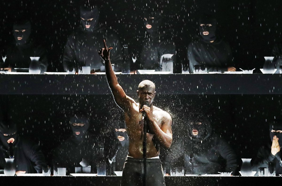 billboard's tweet photo. Stormzy calls out Prime Minister Theresa May and performs "Too Big for Your Boots" &amp; "Blinded by Your Grace" to close #BRITs2018 https://t.co/2rF3ryToJI https://t.co/YxweTLGI5D