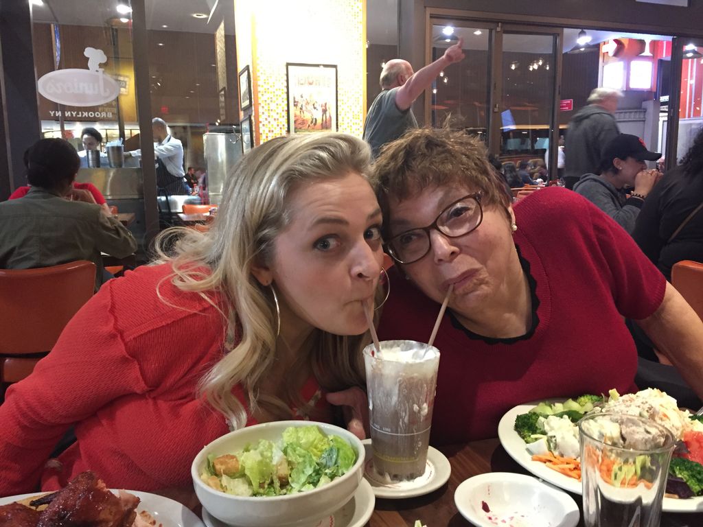 Celebrating #DrunkHistory at @JuniorsCheeseck with @ALISTROKER. #Drunk504 Image of Ali in orange top and Judy in a red top. Both smiling while sharing a chocolate milkshake.