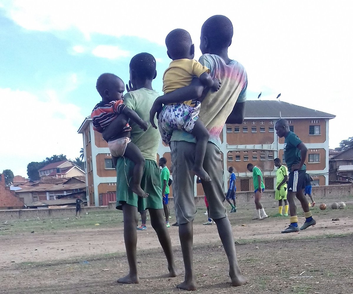 In the slums of #Kisenyi, kids watch a training session of the area's footballers. In the slum area such sports activities are used to engage youth and keep them off bad habits. #Kampala