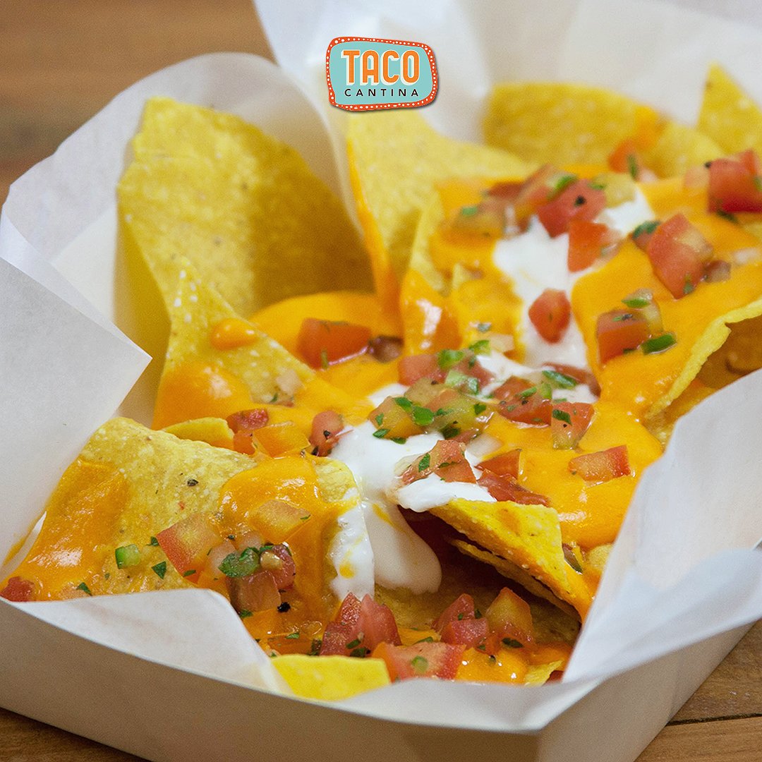 Supreme Nachos - Nachos with Cheese, sour cream and chunks of tomatoes and bell peppers.
