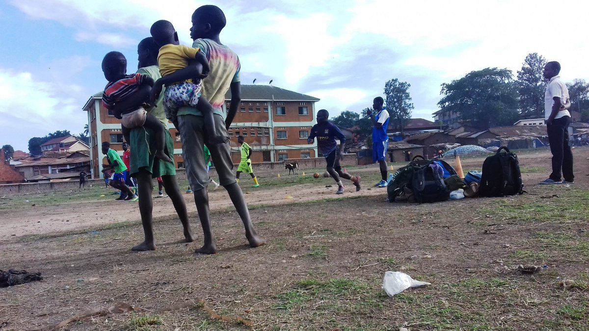 Kids is the slums of Railway Grounds, #Nsambya - #Kampala watch a football session. In the right hand corner is a pile of used plastic bottles, besides wooden residential shades. #Uganda <a href="/ChaffinchTweet/">Chaffinch</a> <a href="/streetchildren/">CSC</a> <a href="/GladsHouse/">Glads House Kenya</a> <a href="/InequalityQ/">InequalityQuestion</a>
