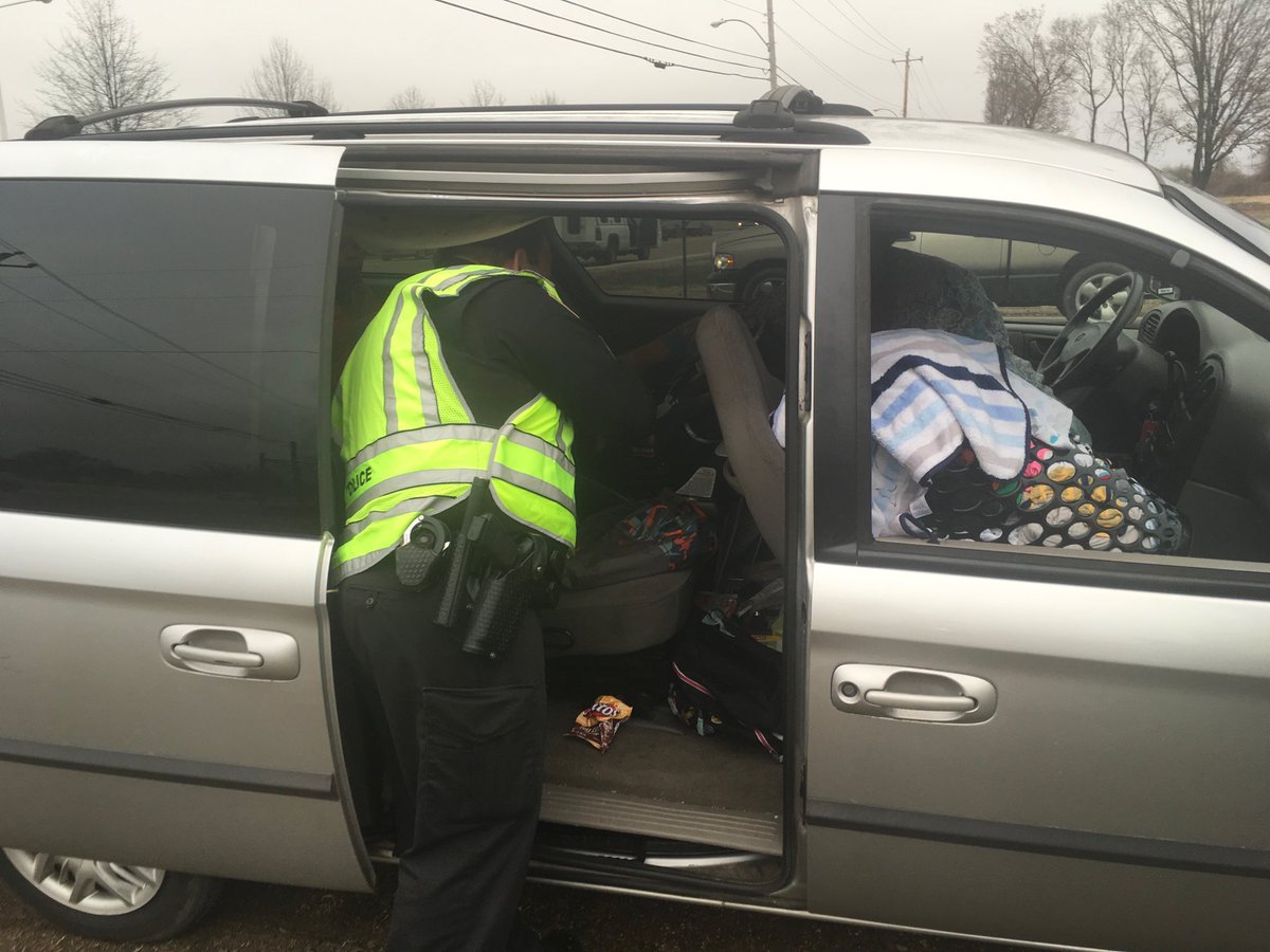 Officers helping driver with proper use of child restraints