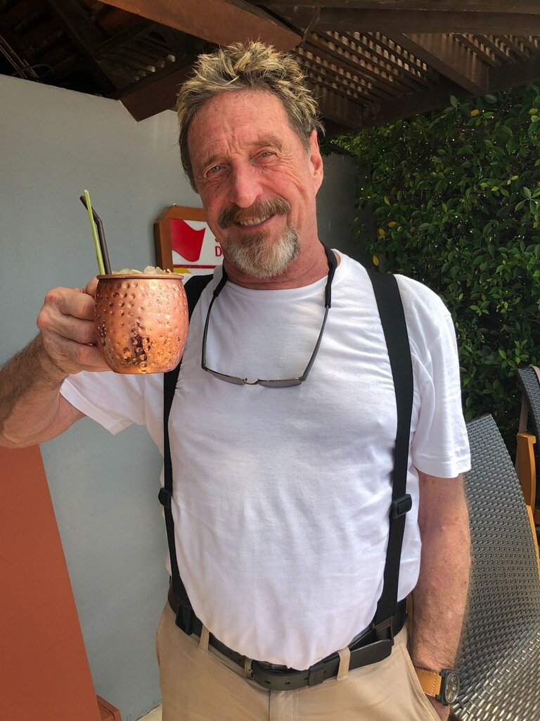 officialmcafee's tweet photo. Greetings from Sri Lanka. I wanted to show the sophistication of alcohol consumption here. Also, the enormous difference in power between my suspenders and Luke's. I have over 50 years of suspender experience. I am the master of suspended manipulation and augmentation. https://t.co/gwkBX02QDb