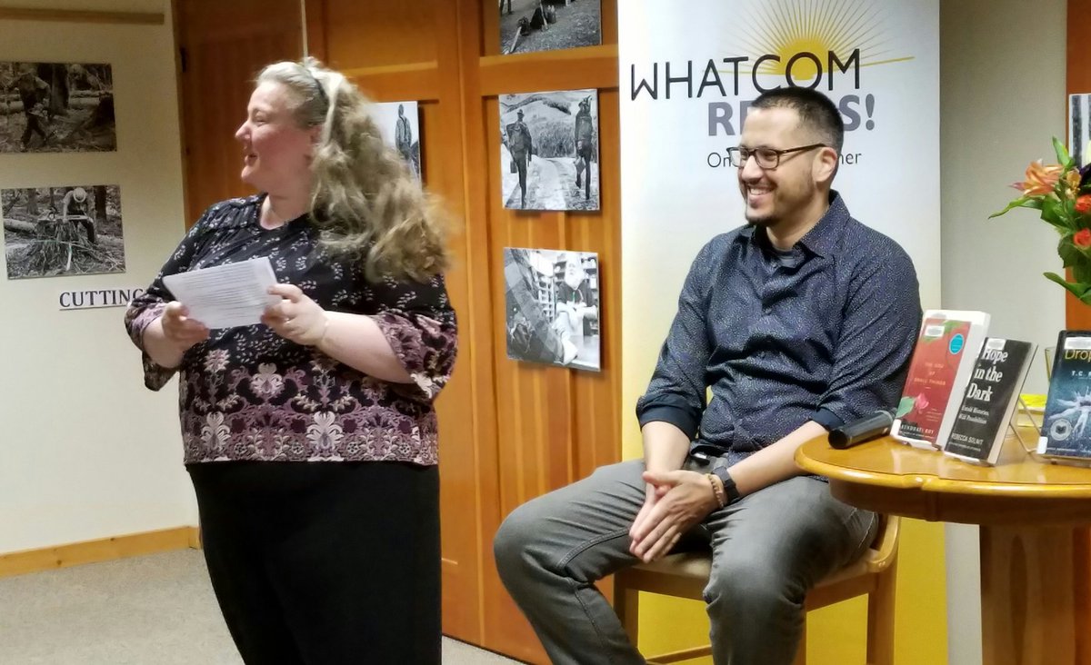 WhatcomREADS's tweet photo. Sarah from @VillageBksBham introduces @sunilyapa at the @wclslibraries Deming Library for his @WhatcomREADS presentation "Digging Deeper," a discussion of five books that have inspired him as a writer. #heartmusclefist https://t.co/fjNHhGuB9Z