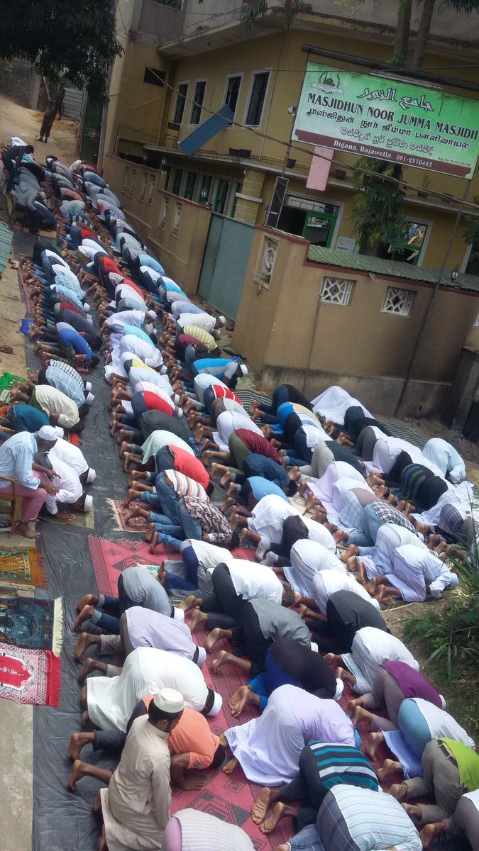 razanahmedd's tweet photo. #Digana #lka prayers on the road. Outside the Mosque unusable after destruction. Under armed military protection from both ends https://t.co/FJZhLViLtp