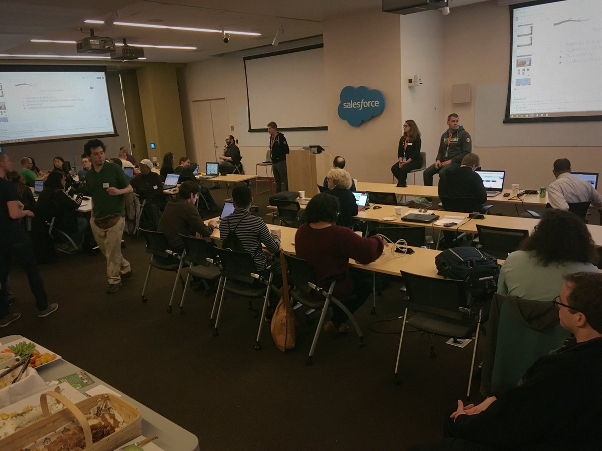 An image of a room full of tables with individuals seated at them.