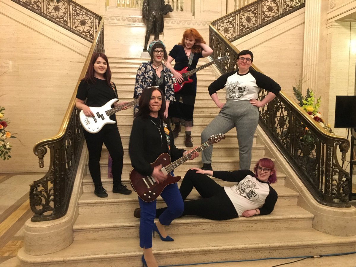 grs_ni's tweet photo. It’s only @ClareBaileyGPNI playing the guitar of @sister_ghost_ with GRSNI tutors @shannondelores @alanahrama and graduates Ciara, Becca and Maeve on the stairs of #Stormont, Parliament buildings in Belfast after playing #AlternativeUlster and #RebelGirl at #MsAlternativeUlster ! https://t.co/8mrA9LOGNS