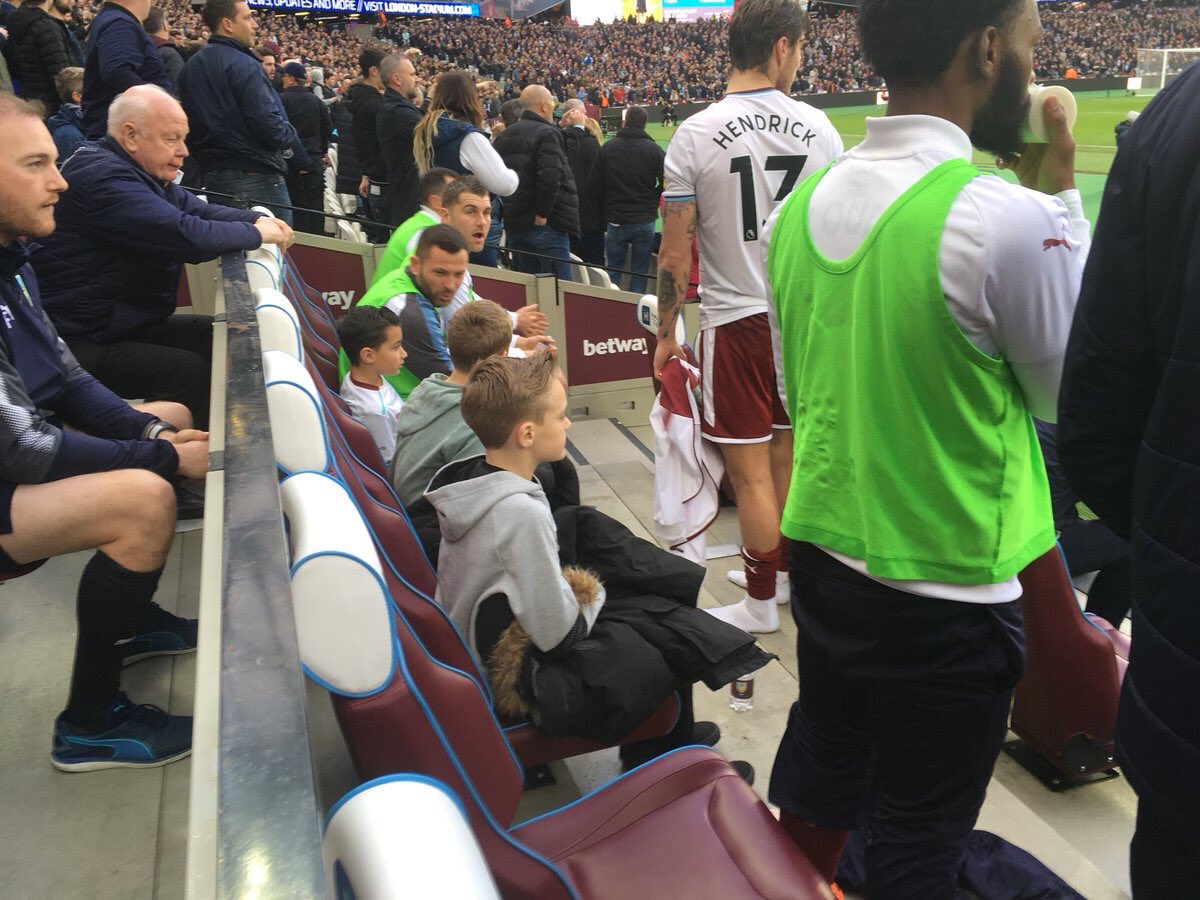 HashtagCharan's tweet photo. Let's take a moment to appreciate the Burnley substitutes who've let young West Ham fans sit in their seats on the bench due to trouble in the crowd. Top lads. https://t.co/oEYJHgmwFk