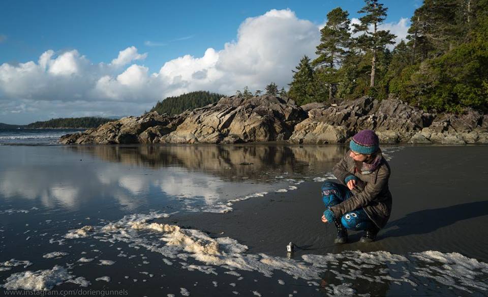 Mika fishing with a GoPro camera in the surf line of a beach.