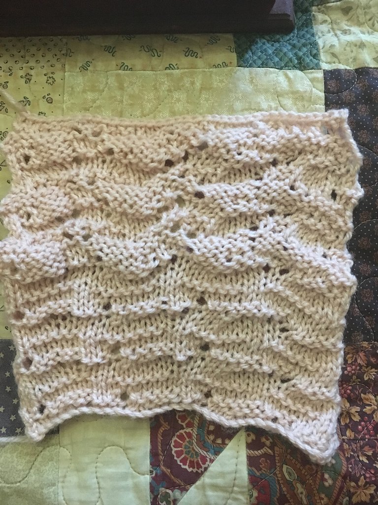 Top half of the knitted swatch has big horizontal protrusions. Bottom of the swatch has smaller, thinner ridges.