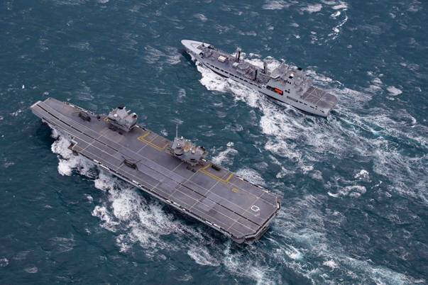 Aerial view of QNLZ and RFA Tidespring at sea next to each other.