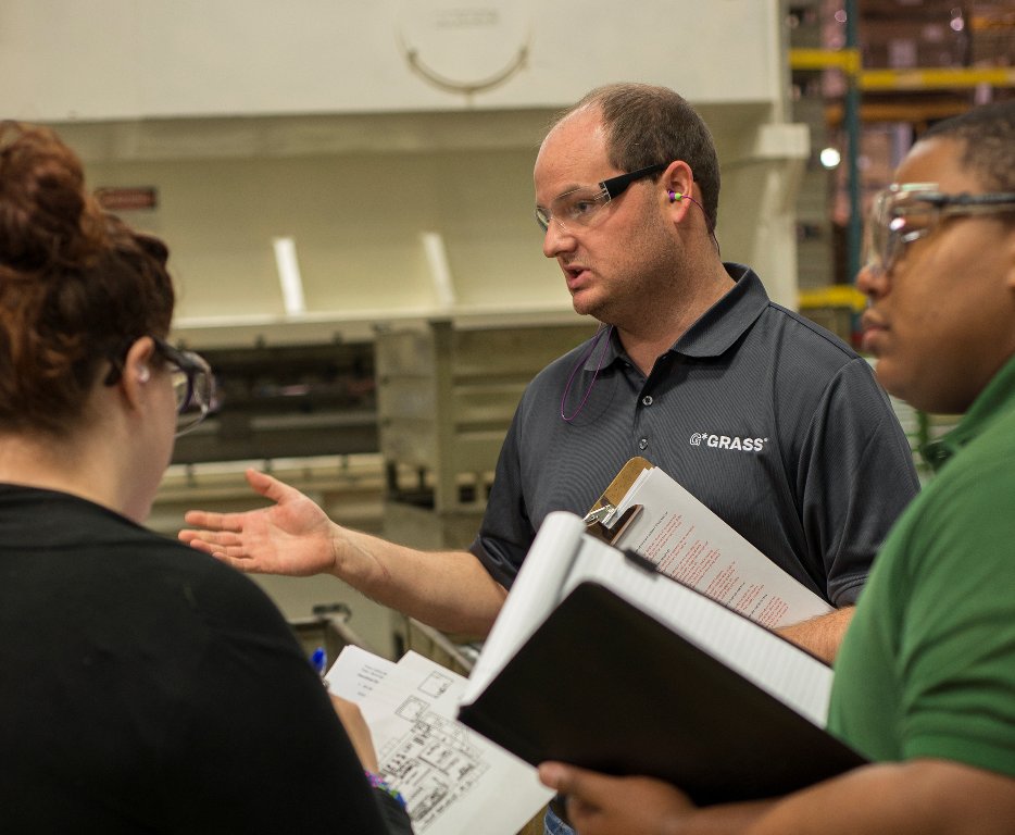 grassusa's tweet photo. Focus On: Our People. Grass America is a multi-faceted, innovative facility where our designers are our engineers. Pictured is Manufacturing Engineer Zach Gardner discussing Work Design with UNCG graduate students this month. #GrassAmerica #ThinkingForwardTuesday #TuesdayThoughts https://t.co/jV9eqXRqxE