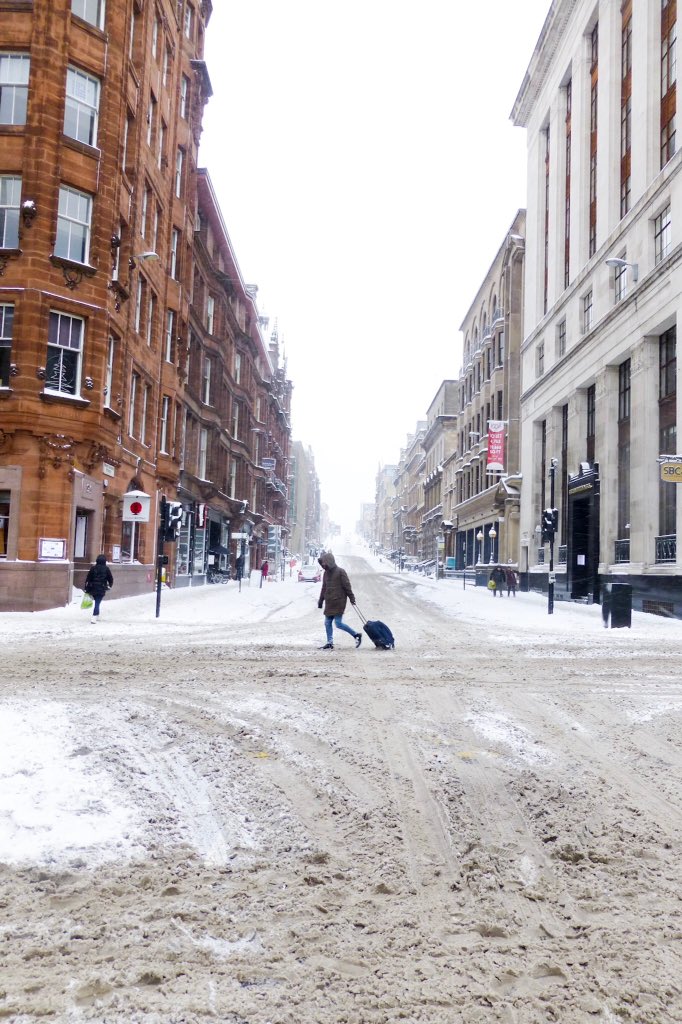DiscvrScotland's tweet photo. An unfortunate tourist trundles through the deserted streets of Glasgow. The bad news is that the snow has just started AGAIN! #glasgow snow #glasgow #BeastFromTheEast #scotland https://t.co/ZkeLPtXM4Z