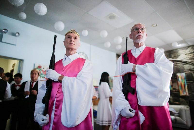 Reuters's tweet photo. Couples lug AR-15 assault rifles to Pennsylvania church blessing https://t.co/9RgJBc26z1 https://t.co/oYmYPxui1t