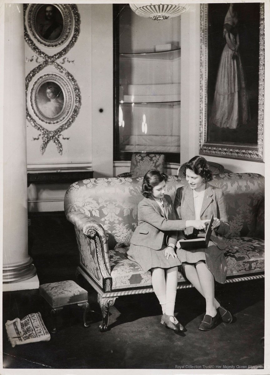 Happy #WorldBookDay! 
This photograph was taken in c.1940 and shows The Queen, then Princess Elizabeth, reading with Princess Margaret in Buckingham Palace.