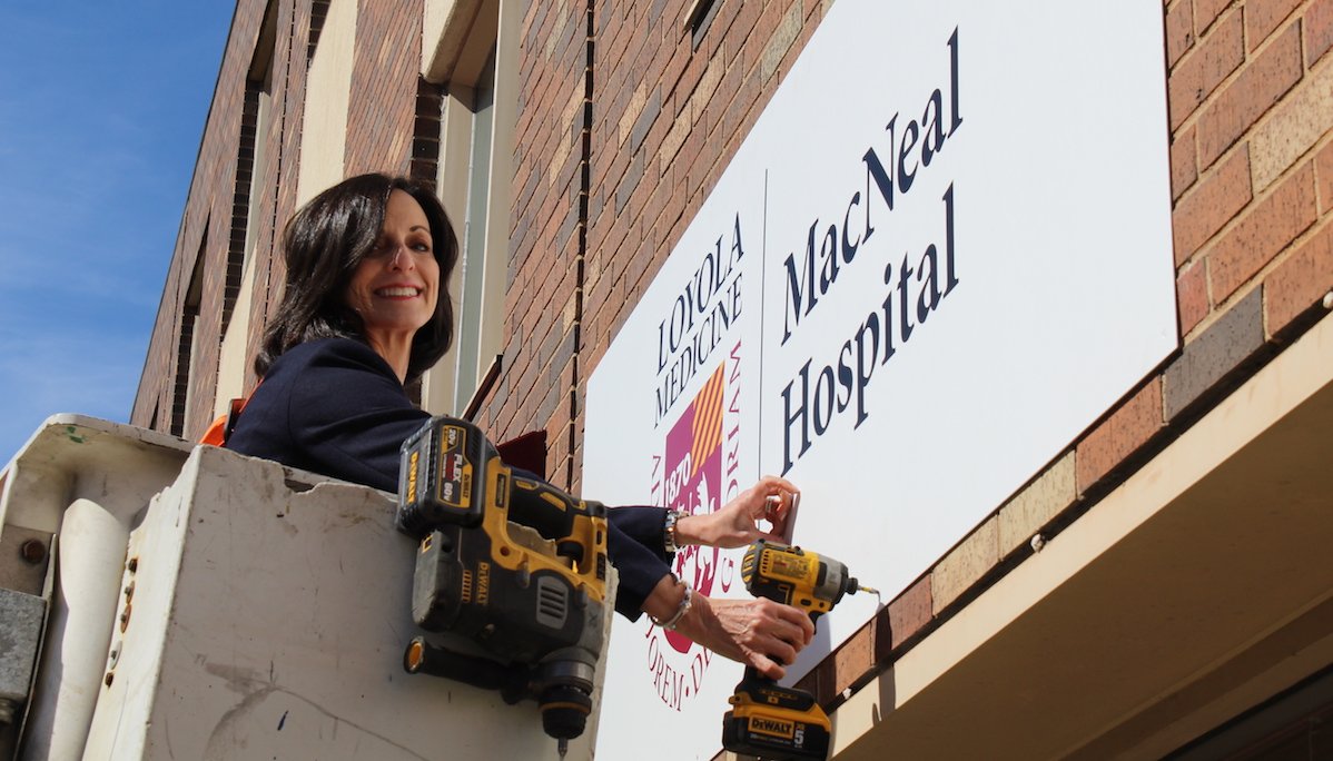 MacNeal Hospital President M.E. Cleary lends a hand during the installation of new signs a day after the hospital joined Loyola Medicine. #macneal #loyolamedicine #bodyandsoul