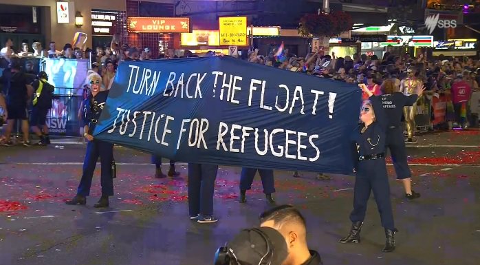 AnarchistPink's tweet photo. Pro-#Refugee Float Facing Off Against the Liberal Party float who were marching behind them. #JusticeForRefugees #MardiGras40 #mardigras2018 https://t.co/QB3hIUU5LT