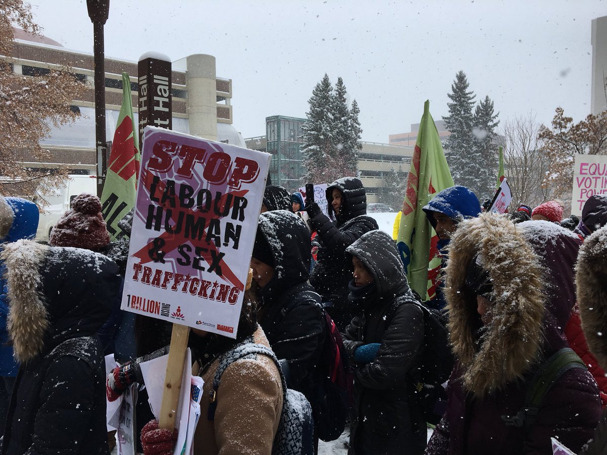 Une cinquantaine de femmes et d'hommes marchent sur l'avenue Whyte à Edmonton dans le cadre de la journée internationale de la femme #rcab #WomenDay