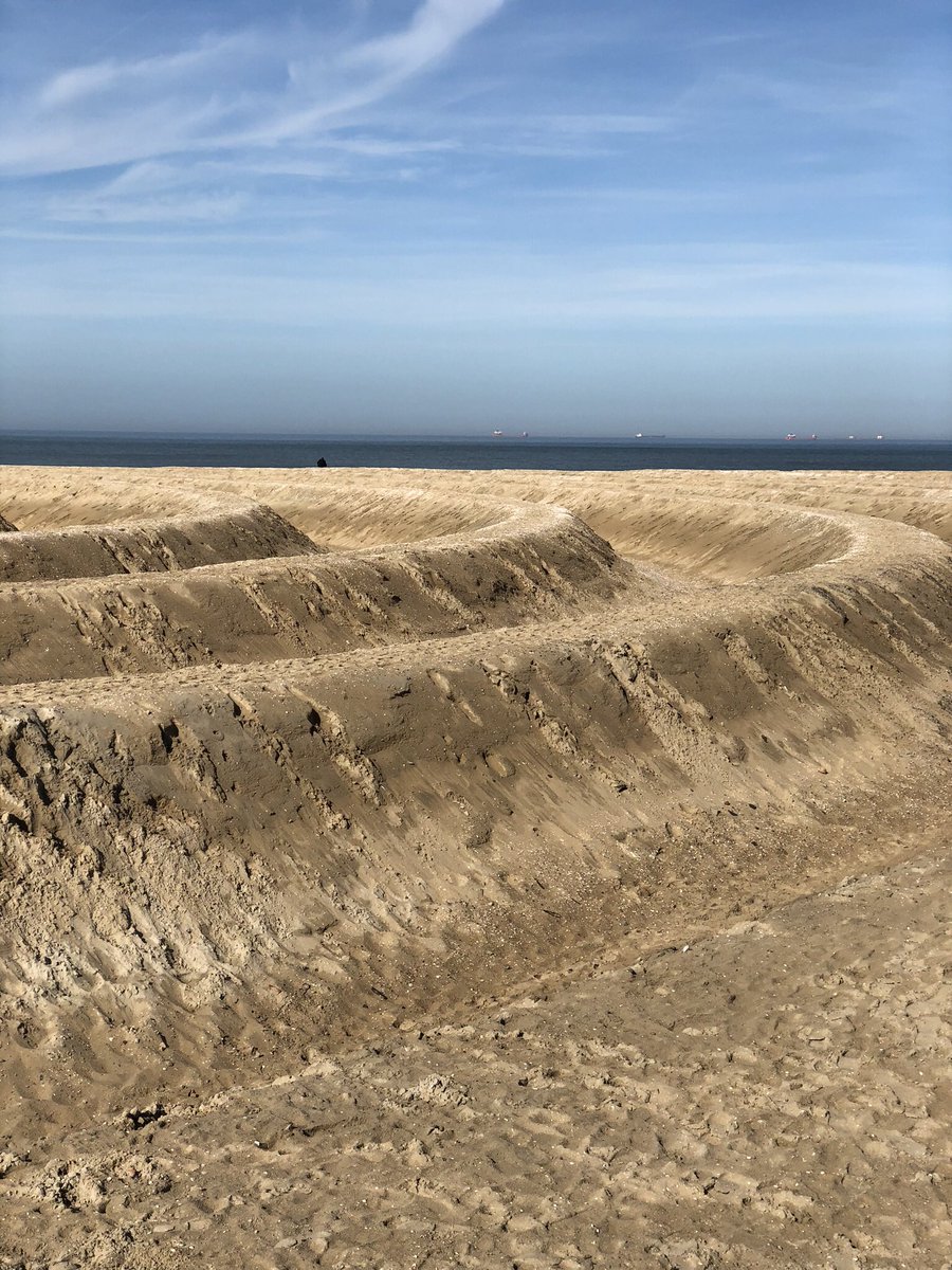 Kunstwerk op Scheveningen. Ziet er inmiddels wat gehavend uit. Het gezicht is mooi. Een aantal knullen ruimt de rommel van de bezoekers op. Prima! Maar waarom graven ze de door hen aangetroffen stenen in? Fundering van het strand? Archeologie? #GemeenteDenHaag #Karstenklein