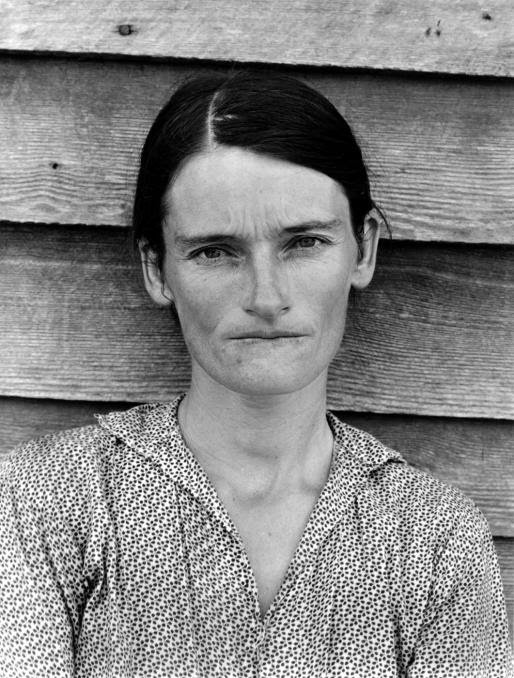 A black and white Depression-era photo of a woman looking sternly at the camera