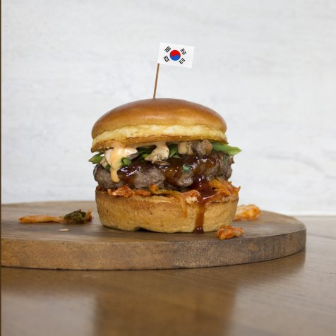 Try the limited-time Korean BBQ Burger! Our 100% Certified Angus Beef® patty sits on a bed of crunchy kimchi and is topped with a savory Bulgogi ketchup, a fresh herb salad with mushrooms, and a creamy Gochujang aioli for a hint of heat.
