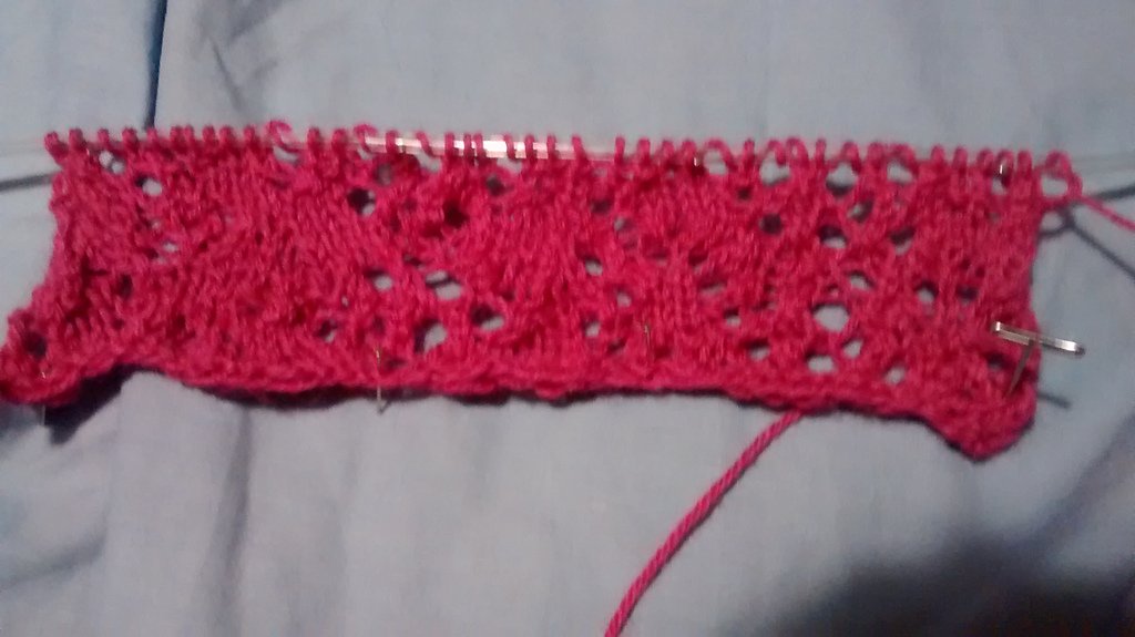 Knitted swatch with very thick sections and blotches alternating with regions of large random holes