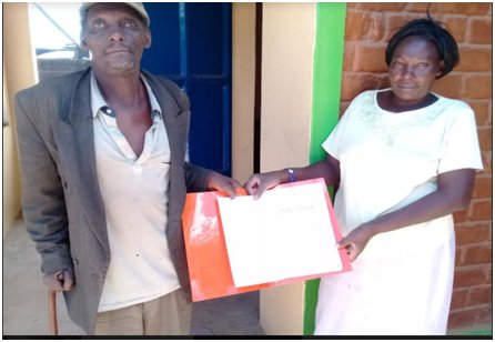 hfh_kenya's tweet photo. This is Ms. Lydia from Laikipia County chosen as a family administrator by the family. She is delivering a land ownership agreement to her blind father. Such agreements are generated by HFH Kenya as a form of incremental land tenure through #solidgroundcampaign #WomenTransform https://t.co/VkLL2szQL7