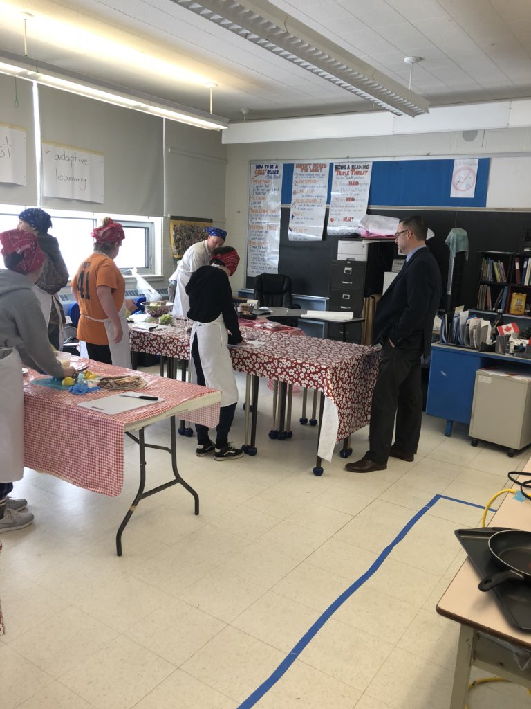 DebraRantz's tweet photo. Students are demonstrating their skills in safe food preparation. Class is humming with initiative and #collaboration. @ScotGillam looks on and I think he is getting hungry! #cookingwithQ @LimestoneFocus @PrCharles_LDSB @LimestoneDSB https://t.co/guIM56gwzi